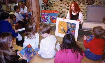 Phoebe Stone showing her artwork to a group of children